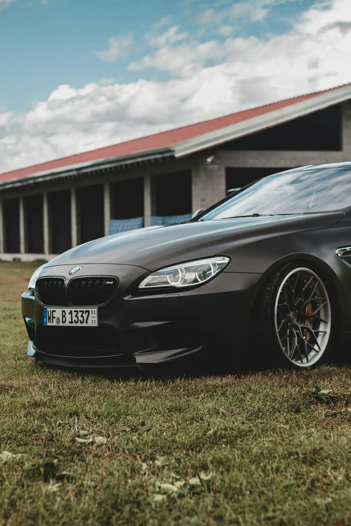 black bmw m 3 coupe parked on green grass field during daytime